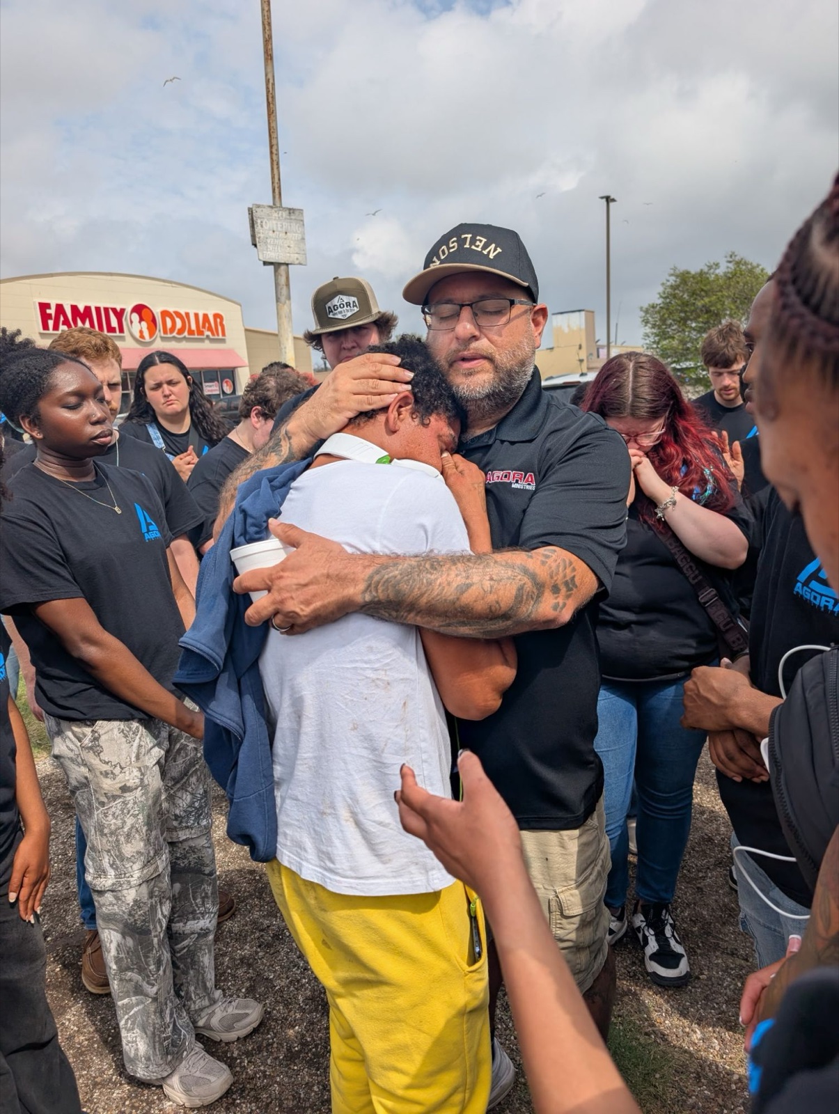 AGORA staff and students praying with a man during street outreach in San Antonio